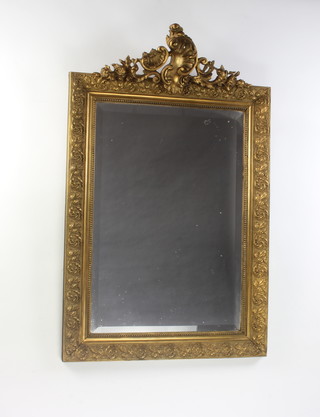 A 19th Century Continental rectangular bevelled plate wall mirror contained in a decorative gilt frame with shield shaped crest 120cm x 75cm 