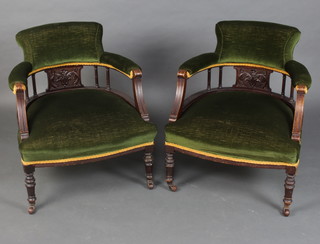 A pair of Edwardian mahogany tub back chairs upholstered in green material with bobbin turned decoration, raised on turned supports 