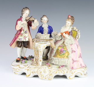 A German conversation group of 3 figures seated at a piano forte, raised on a rococo base 18cm 