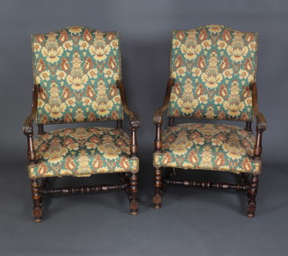 A pair of 17th Century style carved walnut open arm chairs with upholstered seats and backs, raised on turned supports with an H framed stretcher 