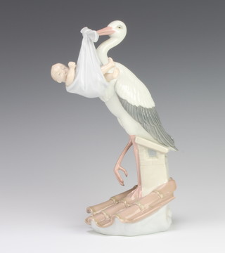 A Lladro figure of a Stork sitting on a chimney pot with a baby tied in a blanket no.6228 25cm 