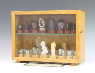 A collection of 32 geological samples to be used as chess pieces contained within a glazed oak display cabinet 
