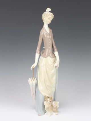 A Lladro figure of a lady holding an umbrella with a Chihuahua at her feet 34cm 