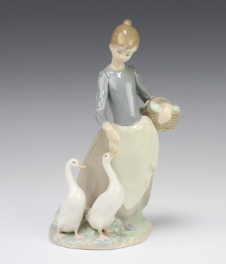 A Lladro figure of a girl holding a basket feeding geese 24cm 