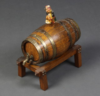 A coopered oak spirit barrel raised on a trestle base with metal spicket 20cm x 28cm x 12cm 