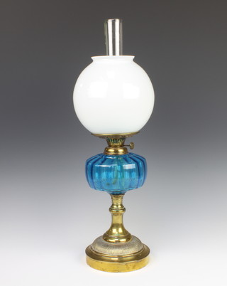 A Victorian blue glass oil lamp reservoir with opaque glass shade and chimney, raised on a gilt metal base 58cm x 17cm 