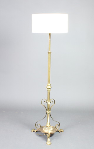 A Victorian brass adjustable standard oil lamp converted to electricity, raised on a circular base with pad feet
