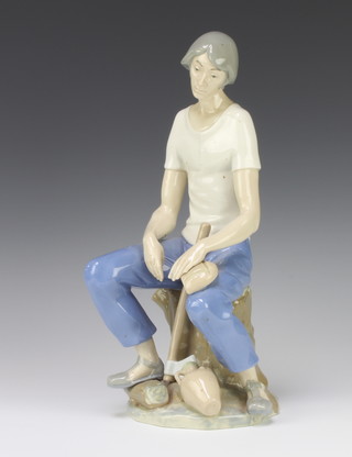 A Spanish porcelain figure of a seated woodsman 32cm 