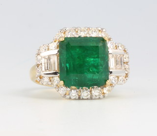An 18ct yellow gold emerald and diamond cluster ring, the centre stone approx. 4.73ct surrounded by baguette diamonds 0.27ct and brilliant cut diamonds 0.6ct, size L 1/2