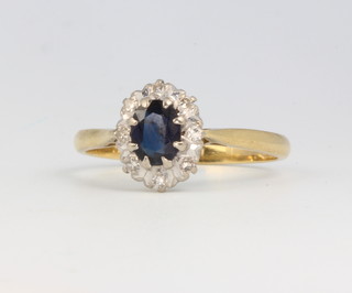 An 18ct yellow gold oval sapphire and diamond cluster ring size R 