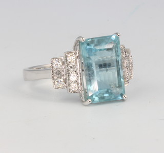 An 18ct white gold Art Deco style aquamarine and diamond ring, the centre stone approx. 4.25ct flanked by brilliant cut diamonds 0.36ct, size N 