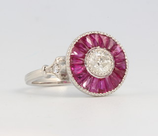 A platinum ruby and diamond target ring, the centre diamond approx. 0.5ct size M  