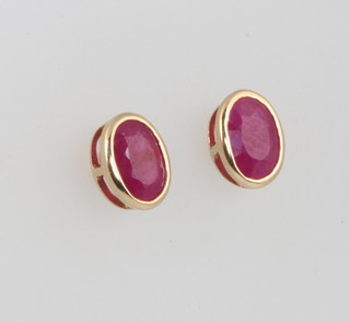 A pair of yellow gold oval cut ruby ear studs approx 0.75ct 