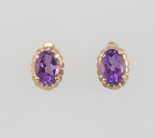 A pair of yellow gold oval cut amethyst ear studs 8mm 