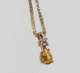 A 9ct yellow gold pear cut yellow sapphire and diamond pendant on a ditto chain 8mm 