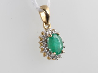 A 9ct yellow gold oval emerald and diamond pendant 16mm 