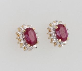 A pair of 9ct yellow gold oval ruby and diamond cluster ear studs 10mm