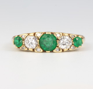 An 18ct yellow gold 3 stone emerald and 2 stone diamond ring, the diamonds 0.4ct, the emeralds 0.6ct size N 