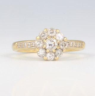 An 18ct yellow gold diamond cluster ring with diamond shoulders, size N 