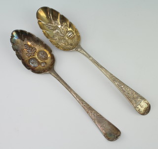Two early Georgian silver berry spoons with floral bowls and gilt decoration 126 grams, rubbed marks 