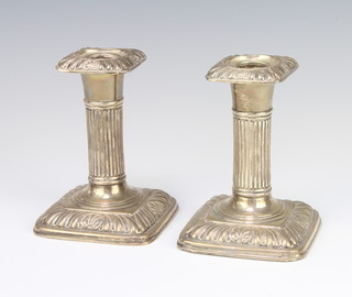 A pair of Edwardian repousse silver dwarf candlesticks with scroll decoration 13cm 