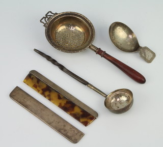 A George III silver caddy spoon of plain form with angular handle London 1807, a toddy ladle, strainer and comb case 