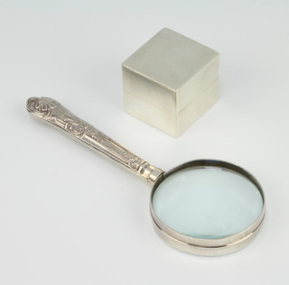 A square silver ring box and a silver handled magnifying glass 