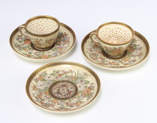 A pair of Satsuma teacups and saucers decorated with flowers with seal marks to base and a single saucer