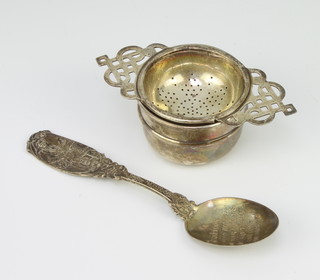 A silver tea strainer and stand Sheffield 1934 and a Sterling silver spoon 95 grams