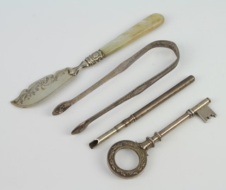 A Continental silver presentation key, a pair of sugar tongs, nib holder and butter knife