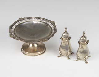 A silver tazza with pierced rim 12cm London 1919 and a pair of peppers 136 grams