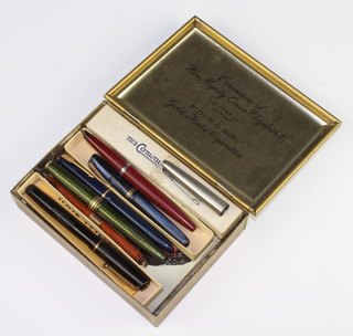 A Conway Stewart 84 red marbled fountain pen boxed, 4 other fountain pens, a pencil and minor postcards in a 1953 commemorative tin