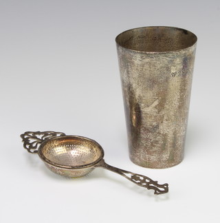 An Edwardian silver beaker of plain form London 1908 and a strainer Birmingham 1928, 195 grams