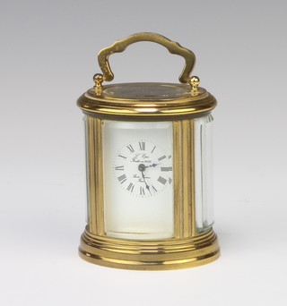 A 20th Century French 8 day carriage timepiece with enamelled and Arabic numerals contained in an oval gilt metal case (no key)