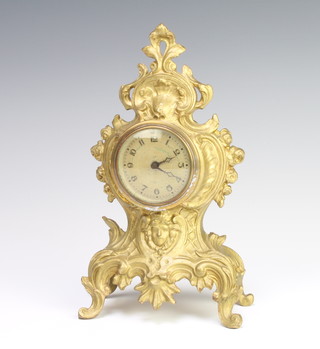 A bedroom timepiece with silvered dial and Arabic numerals contained in a gilt Rococo style case 