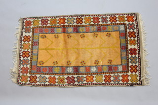 A yellow and blue ground Anatolian rug with stylised tree of life motif to the centre within a 3 row border 128cm x 76cm 
