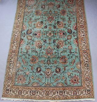 A green and floral patterned Persian Tabriz carpet 365cm x 238cm 