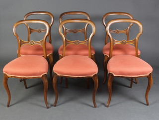 A set of 6 Victorian walnut balloon back dining chairs with carved mid rails and over stuffed seats of serpentine outline, raised on cabriole supports 
