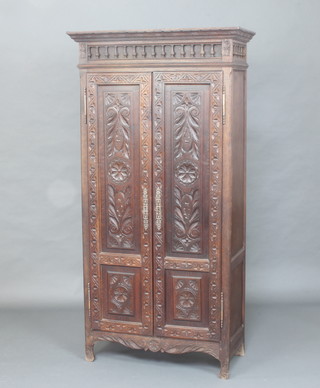 A 19th Century Continental carved oak cabinet, the upper section with moulded cornice and spindle decoration, fitted shelves enclosed by carved panelled doors 176cm h x 89cm w x 40cm d 