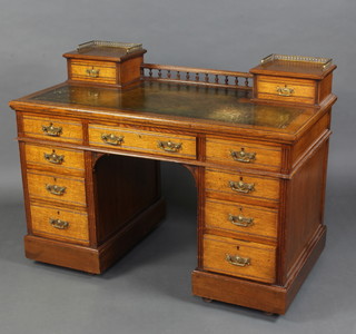A Maple & Company Edwardian oak desk, the upper section fitted 2 shallow drawers with brass gallery inset a tooled leather writing surface above 1 long and 8 short drawers with reeded decoration 91cm h x 122cm w x 165cm d (the desk is in one section and does not come apart)