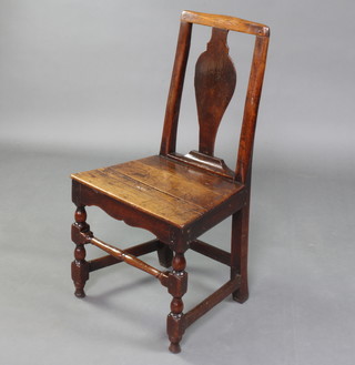 An 18th Century oak hall chair with vase shaped slat back and solid seat raised on turned and block supports
