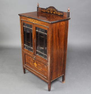 An Edwardian inlaid rosewood music cabinet with raised back, fitted shelves enclosed by astragal glazed panelled doors, the base fitted a fall front inlaid an urn and cover 110cm h x 66cm w x 35cm d 
