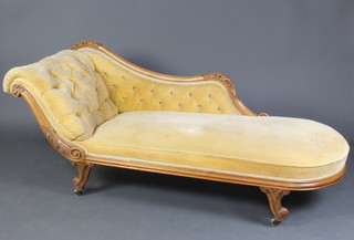 A Victorian carved bleached mahogany chaise longue upholstered in yellow buttoned material, raised on  scroll shaped supports 76cm h x 190cm l x 67cm d  