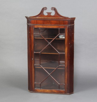 A Georgian style mahogany hanging corner cabinet with broken pediment, fitted shelves enclosed by an astragal glazed panelled door 112cm h x 64cm w x 35cm d 