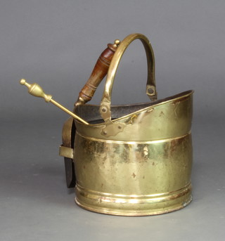 A brass helmet shaped coal scuttle complete with shovel 