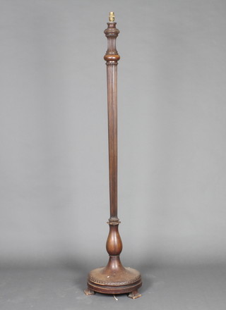 A turned and reeded walnut standard lamp raised on a circular base 154cm h x 30cm diam. 