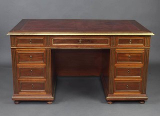 A 19th Century Biedermeier and brass mounted desk with inset brown leather writing surface, and brass mounts throughout, fitted 1 long and 8 short drawers, raised on bun feet 77cm h x 145cm w x 80cm d