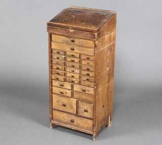 A Victorian compositor's pine pedestal chest, the upper section with slope, the base fitted an arrangement of 3 long drawers and 25 short drawers with tore handles 67cm h x 34cm w x 28cm d 