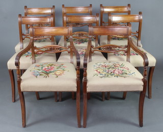 A set of 8 Georgian mahogany bar back dining chairs with shaped mid rails and Berlin woolwork over stuffed seats, raised on sabre supports - 2 carvers and 6 standard 