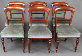 A set of 6 Victorian mahogany spoon back dining chairs with shaped mid rails and over stuffed seats, raised on turned supports 